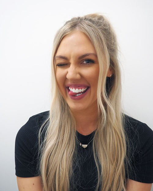 Girl sticking her tongue out and smiling after dental whitening